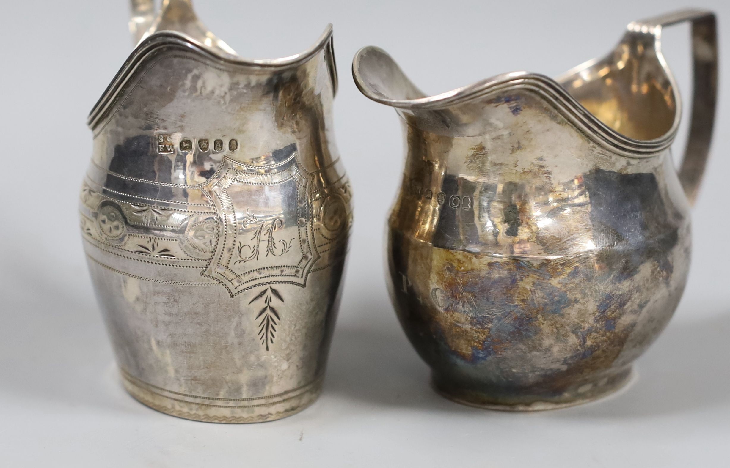 Two George III silver helmet shaped cream jugs, London, 1789 and London, 1796, tallest 10.6cm, 6.5oz.